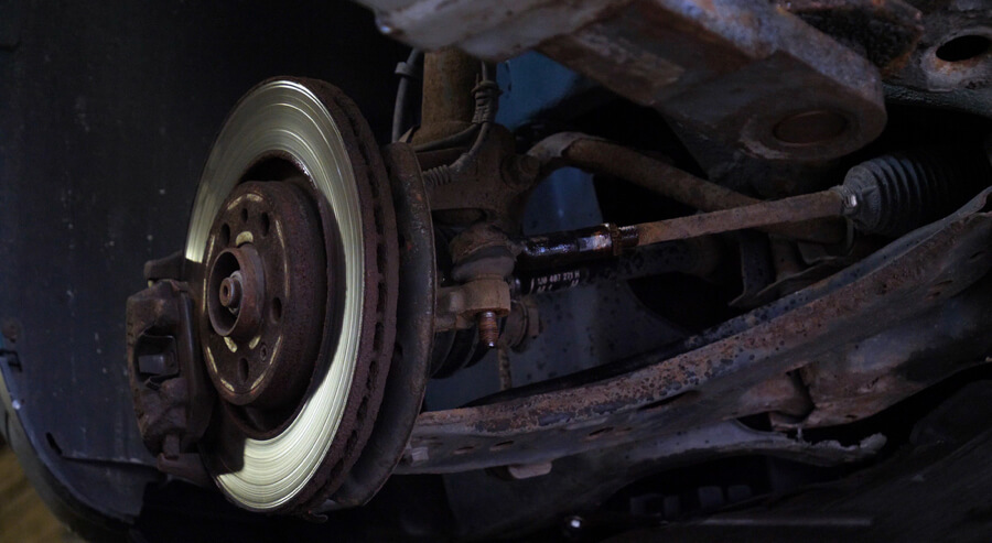 Checking the brake knocking noise in car repair workshop.